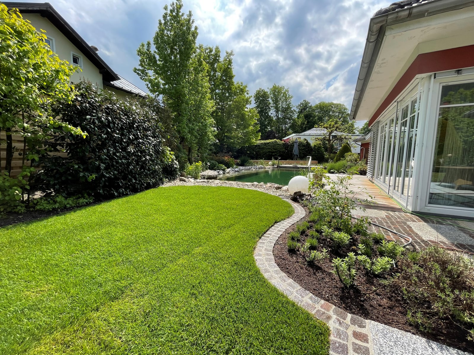 Garten mit geschwungener Rasenkante, Bepflanzung und Teich