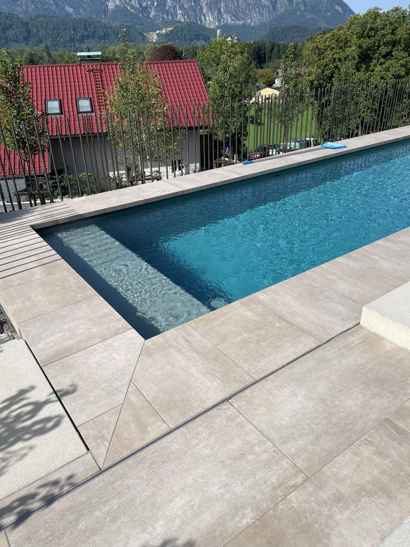 Pool mit hellen Steinplatten und Blick auf die Berge